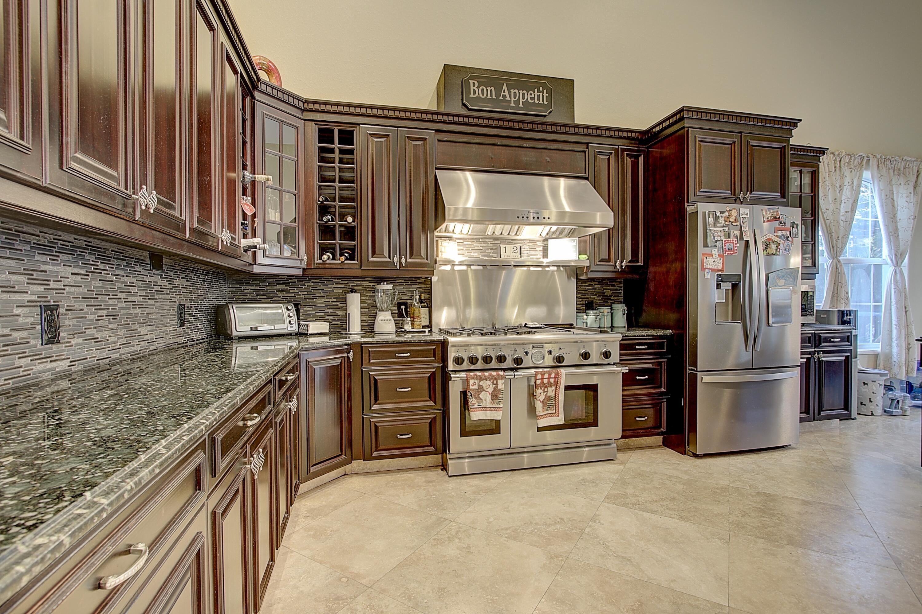 669 Howard Street Fort Pierce, FL 34982 - Photo 7 of 15 a kitchen with stainless steel appliances granite countertop a stove a refrigerator and a sink