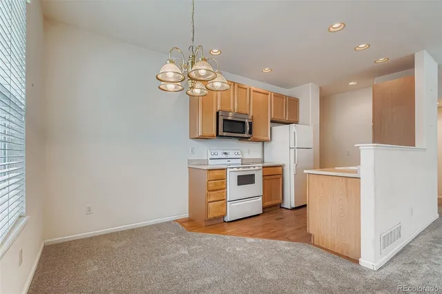 a view of a kitchen with a sink a refrigerator and a stove top oven