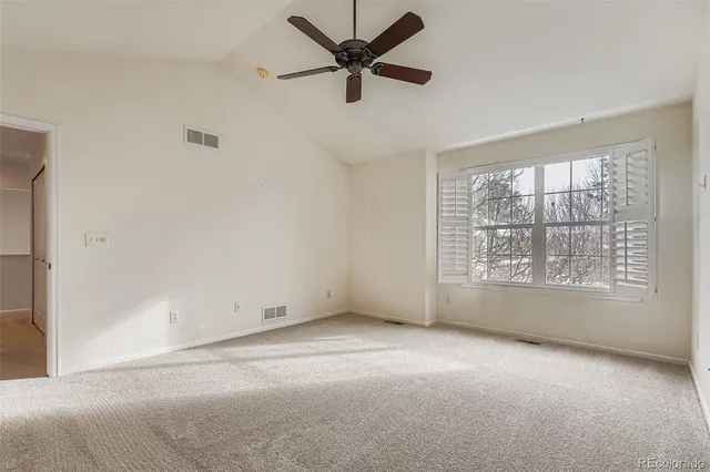 an empty room with a window and a fan