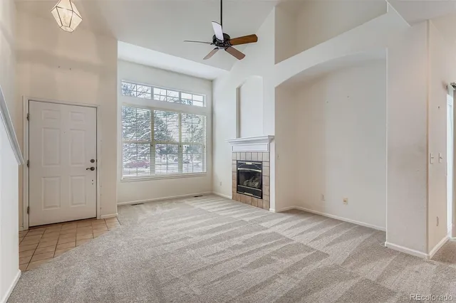an empty room with windows and a fireplace
