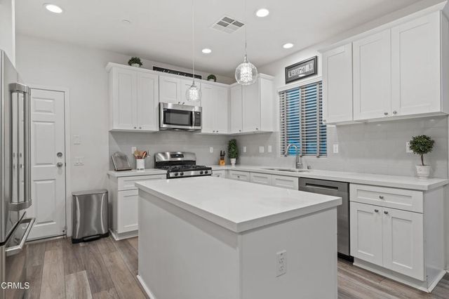 a kitchen with a white cabinets and wooden floor