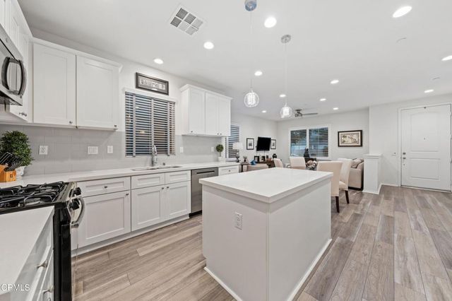 a living room with furniture a flat screen tv and large window