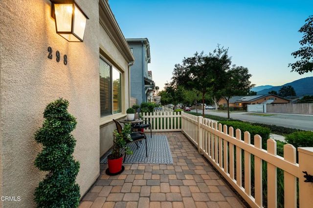 a living room with stainless steel appliances furniture and a flat screen tv