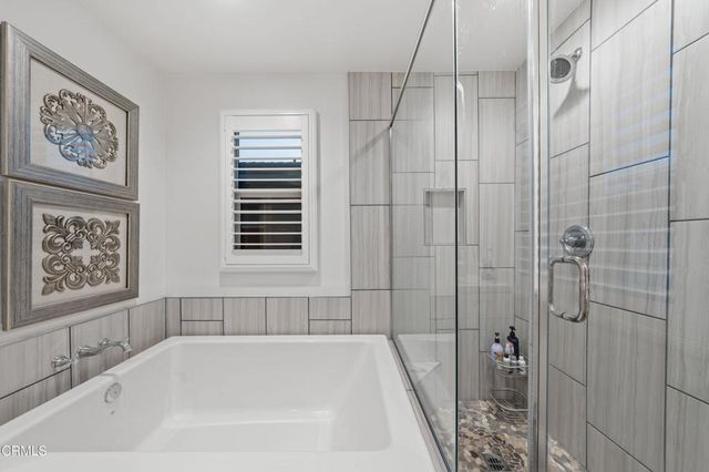 a bathroom with a double vanity sink a mirror and a bathtub