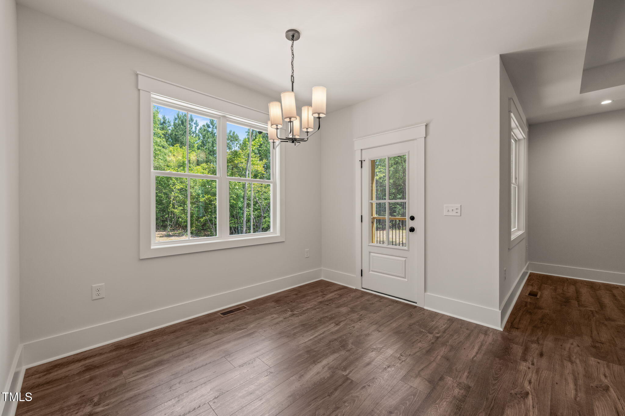 390 Pilot Ridge Road Zebulon, NC 27597 - Photo 13 of 41 an empty room with wooden floor exposed radiator and windows