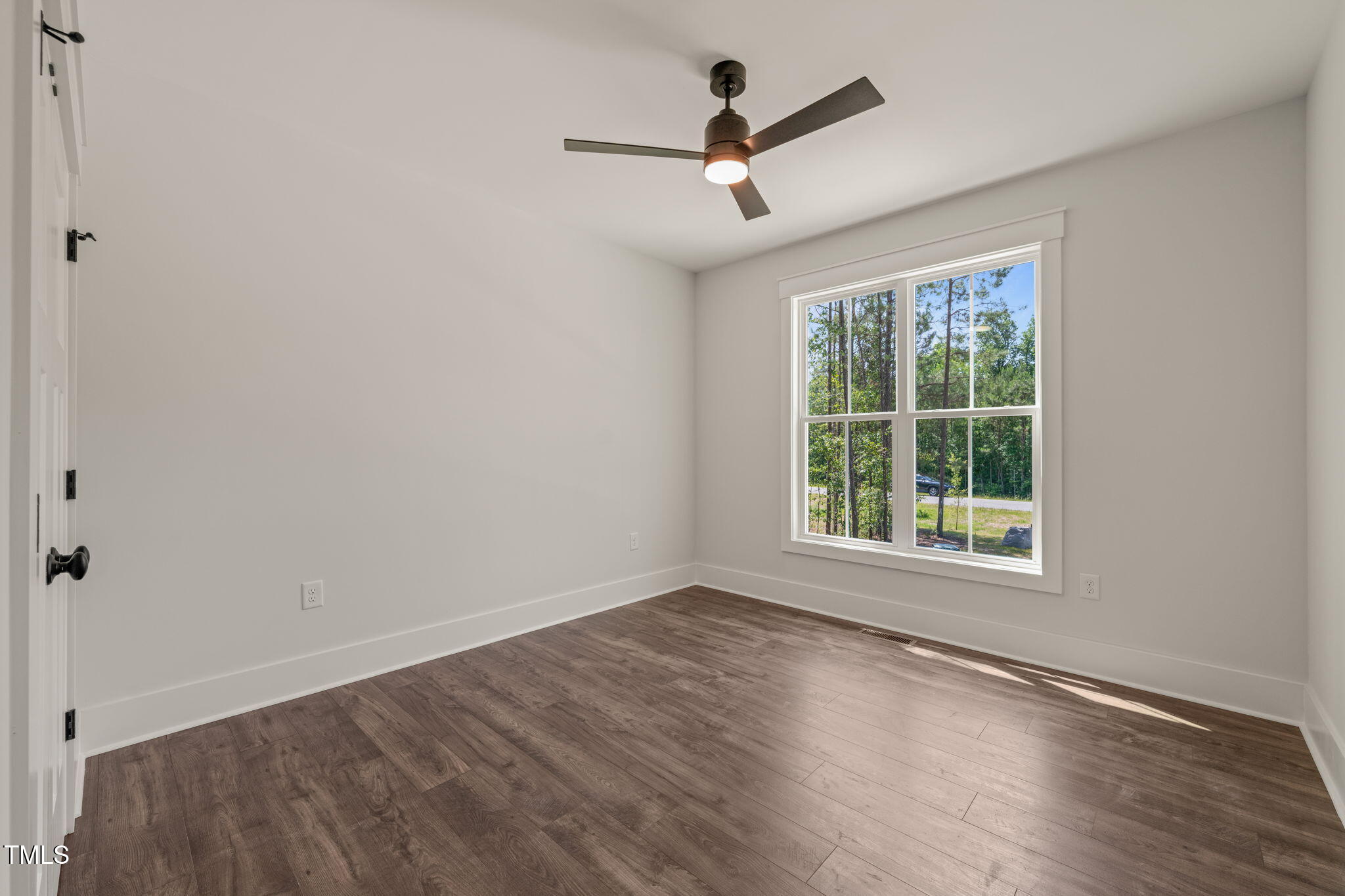 390 Pilot Ridge Road Zebulon, NC 27597 - Photo 24 of 41 an empty room with wooden floor ceiling fan and windows