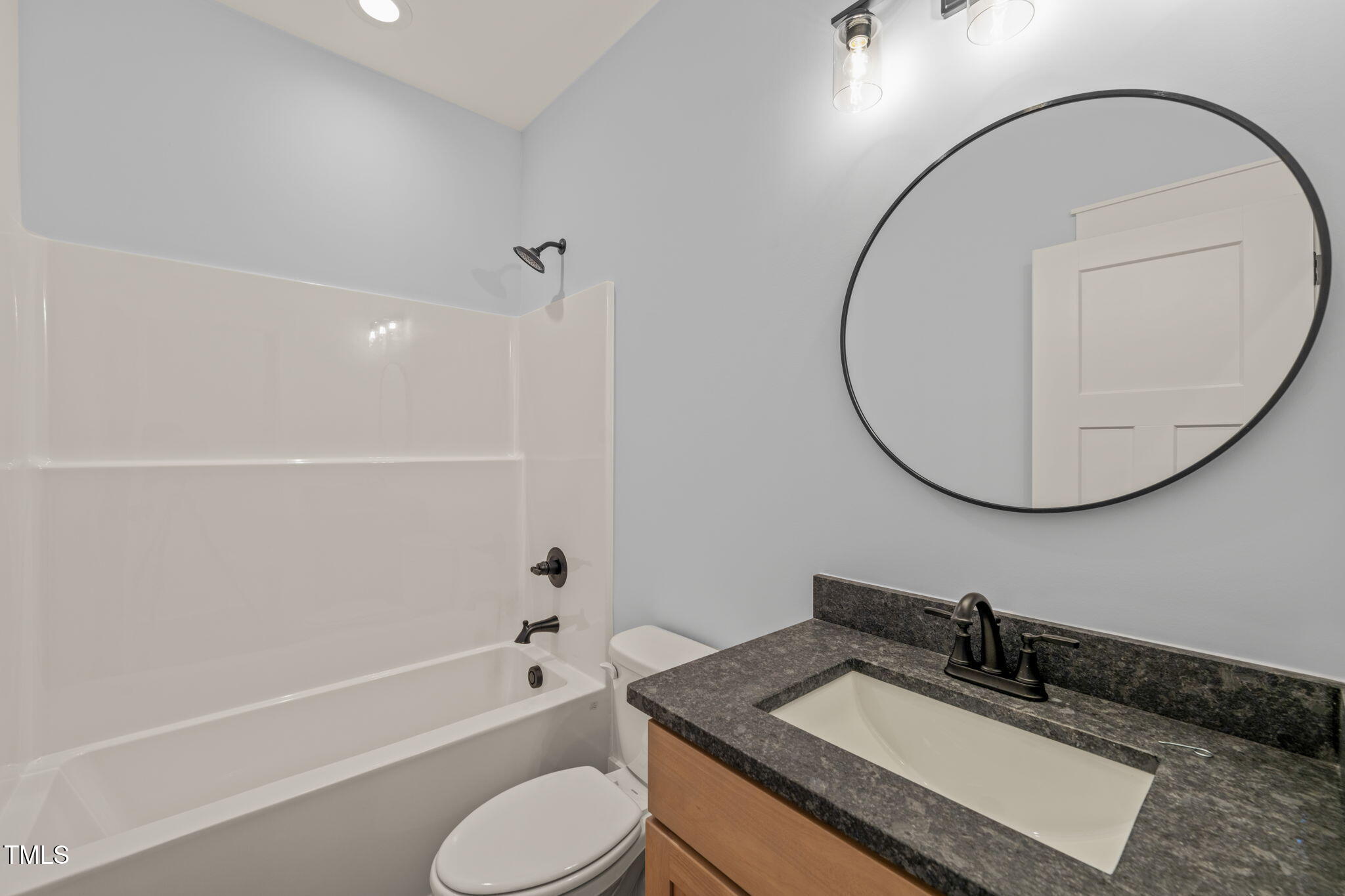 390 Pilot Ridge Road Zebulon, NC 27597 - Photo 26 of 41 a bathroom with a granite countertop sink a toilet and a mirror