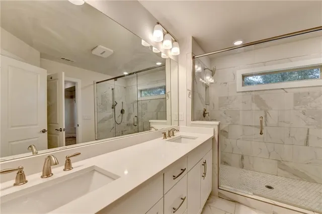 a bathroom with a shower sink and mirror