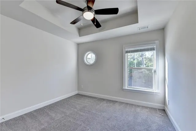 an empty room with windows and fan