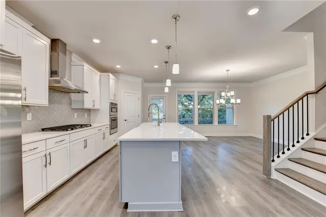 a kitchen with kitchen island a sink and a stove top oven