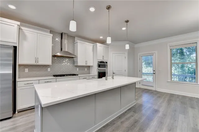a large kitchen with kitchen island a stove a sink a center island and wooden floor