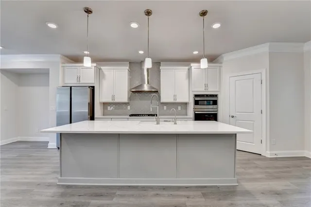 a kitchen with kitchen island a sink stainless steel appliances and cabinets