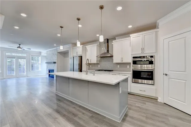 a kitchen with kitchen island a stove a sink and a refrigerator with wooden floor