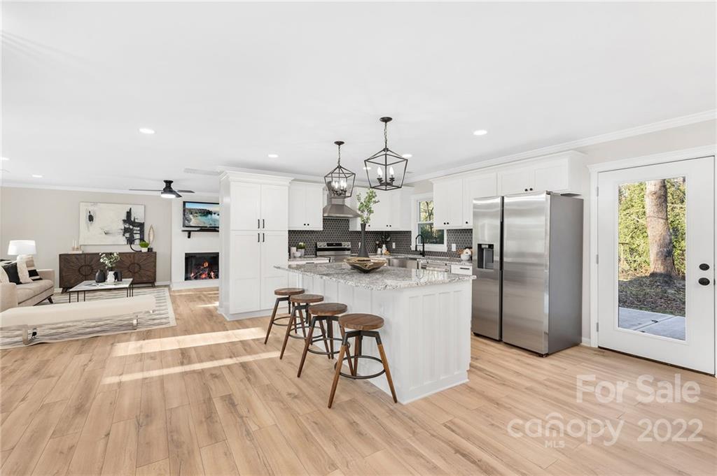 2606 Holbrook Road Fort Mill, SC 29715 - Photo 8 of 23 a kitchen with stainless steel appliances kitchen island granite countertop a refrigerator a stove a sink dishwasher and white cabinets with wooden floor