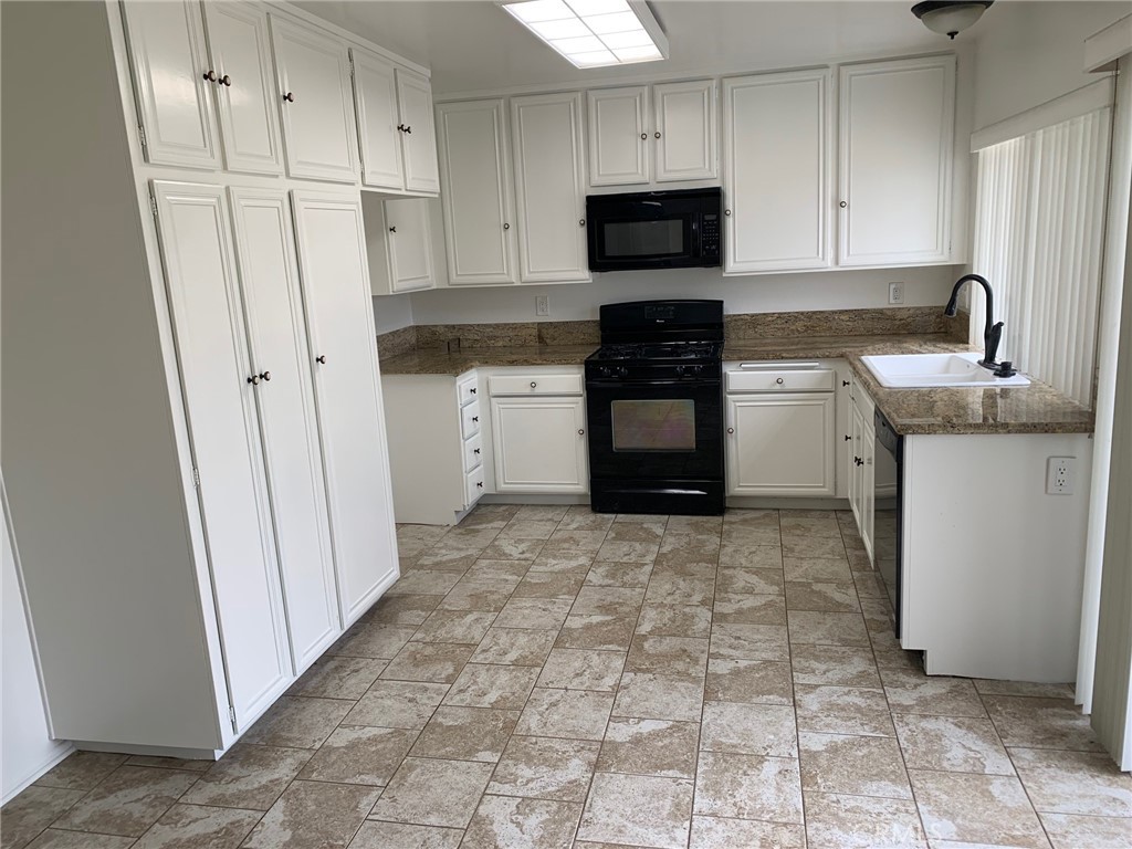 23892 Vía El Rocio Mission Viejo, CA 92691 - Photo 2 of 6 a kitchen with a refrigerator stove and white cabinets
