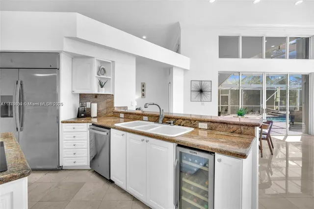 a kitchen with stainless steel appliances granite countertop a table and chairs in it
