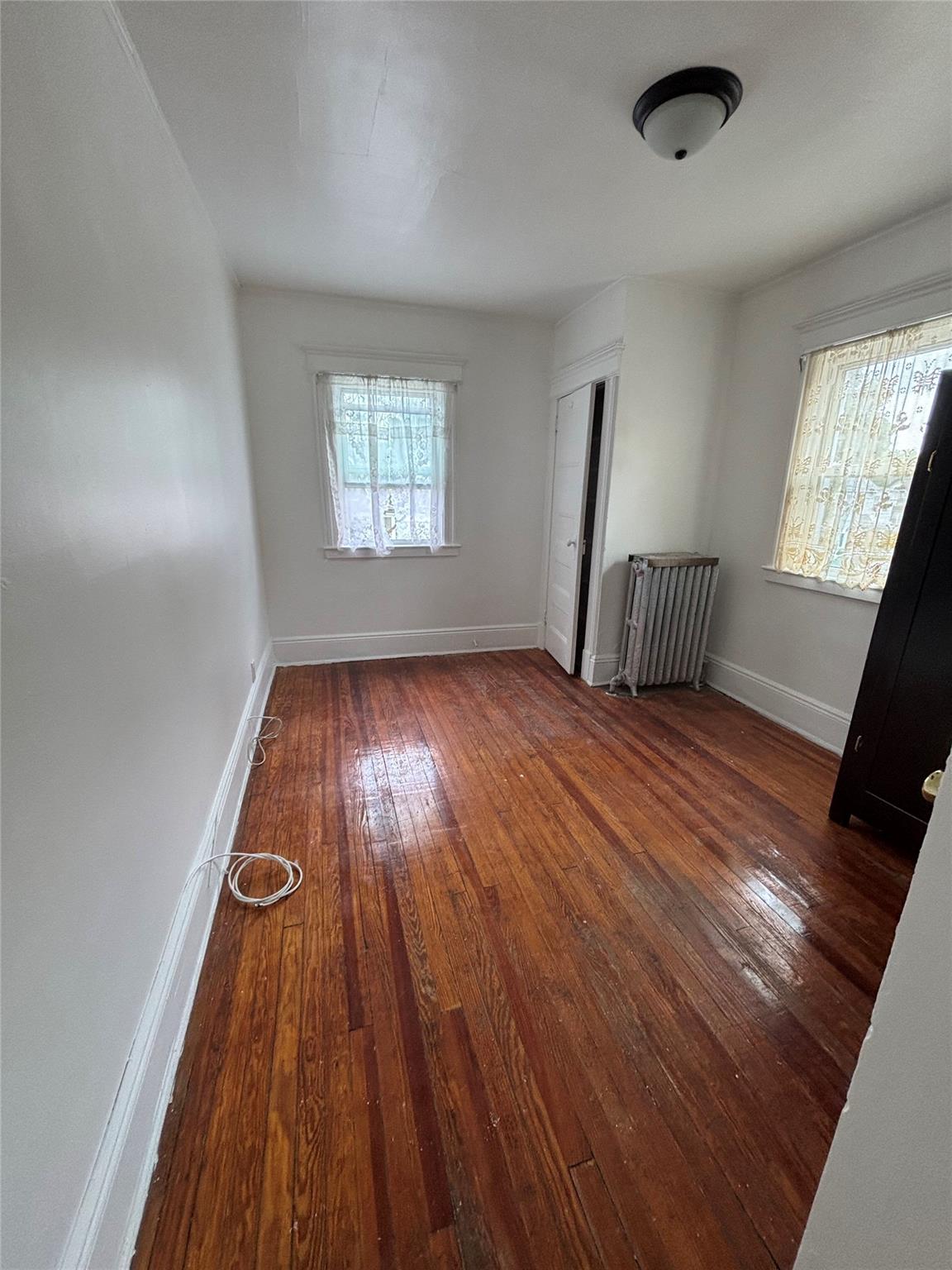219-06 101st Avenue Queens, NY 11429 - Photo 16 of 19 wooden floor in an empty room with a window
