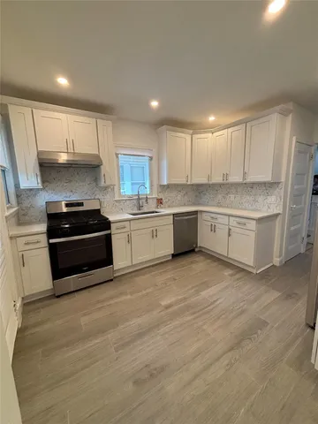 a kitchen with granite countertop a stove and cabinets