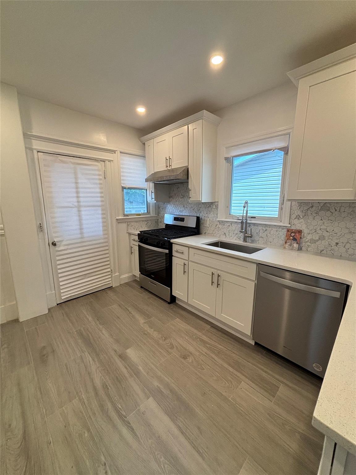 219-06 101st Avenue Queens, NY 11429 - Photo 5 of 19 a kitchen with stainless steel appliances granite countertop a sink a stove a refrigerator with grey cabinets