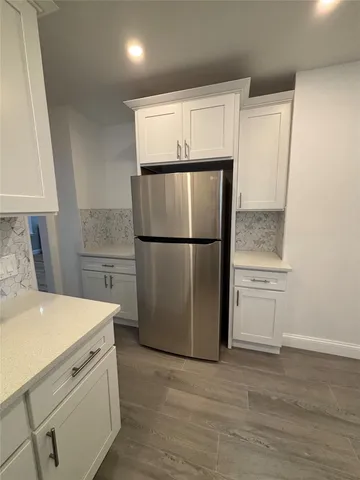 a kitchen with a refrigerator and a stove top oven