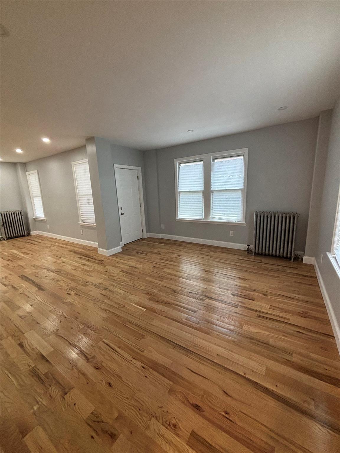 219-06 101st Avenue Queens, NY 11429 - Photo 10 of 19 a view of empty room with wooden floor and fan