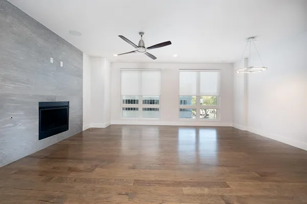an empty room with windows and fireplace