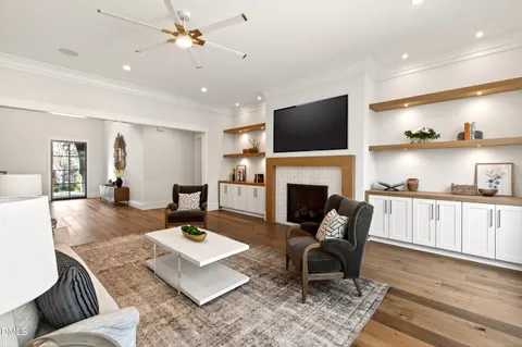 a living room with furniture couches and a dining table with wooden floor