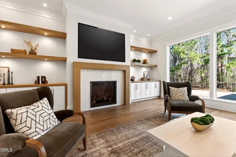 a living room with furniture and a large window with wooden floor