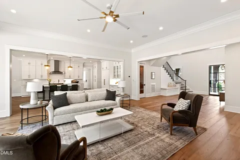 a kitchen with a stove a sink a dining table and chairs with wooden floor