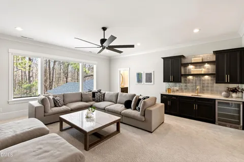 a living room with furniture fireplace and large windows