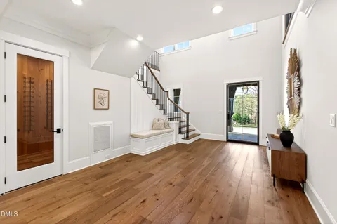 a view of an empty room with wooden floor and a ceiling fan