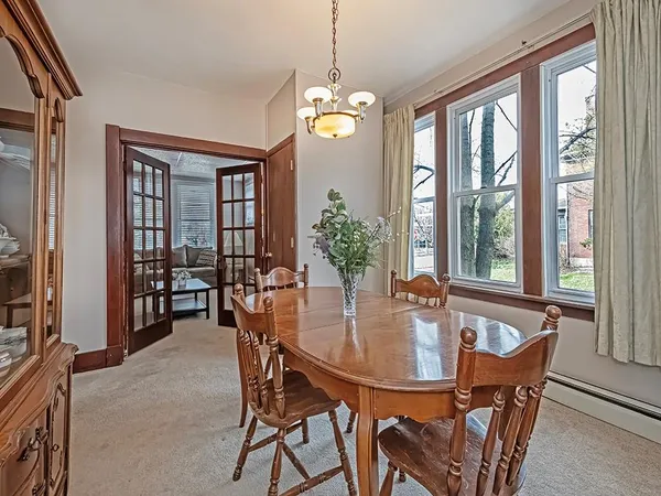 a dining room with furniture potted plants and a chandelier