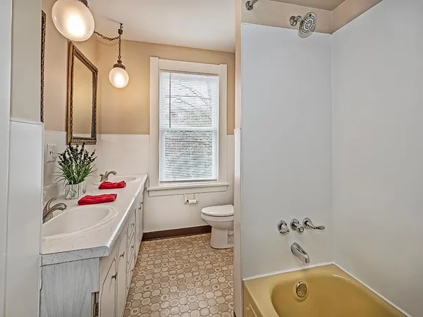 a bathroom with a tub sink and mirror on the wall