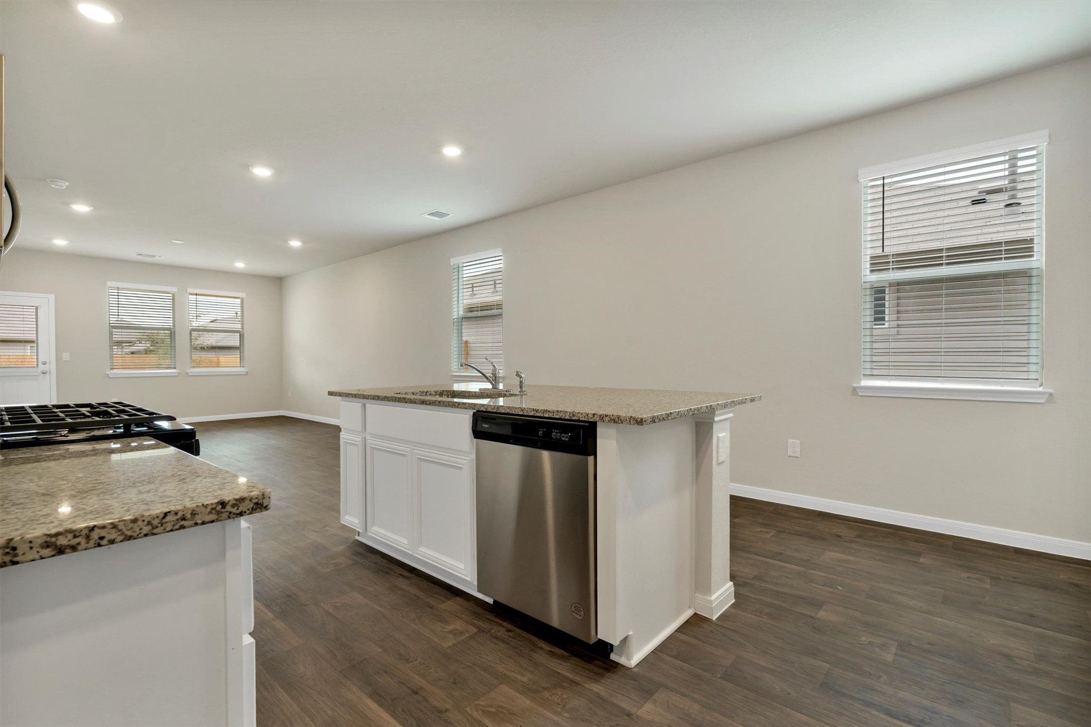 2909 Tweedy Trail Pflugerville, TX 78660 - Photo 17 of 27 A well-lit kitchen with a central island and rich hardwood flooring, ready for culinary endeavors.