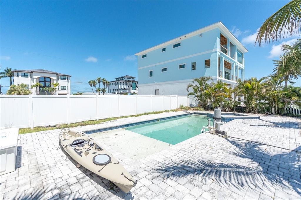 575 Crystal Drive Madeira Beach, FL 33708 - Photo 7 of 16 a view of a house with a backyard and garden