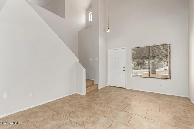 a view of an empty room with window and stairs