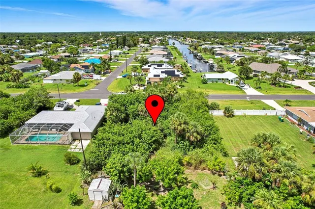 an aerial view of residential houses with outdoor space and trees