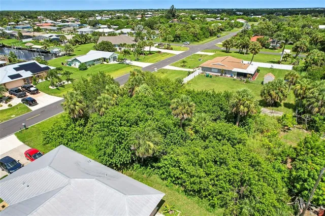 an aerial view of residential house with outdoor space and trees all around