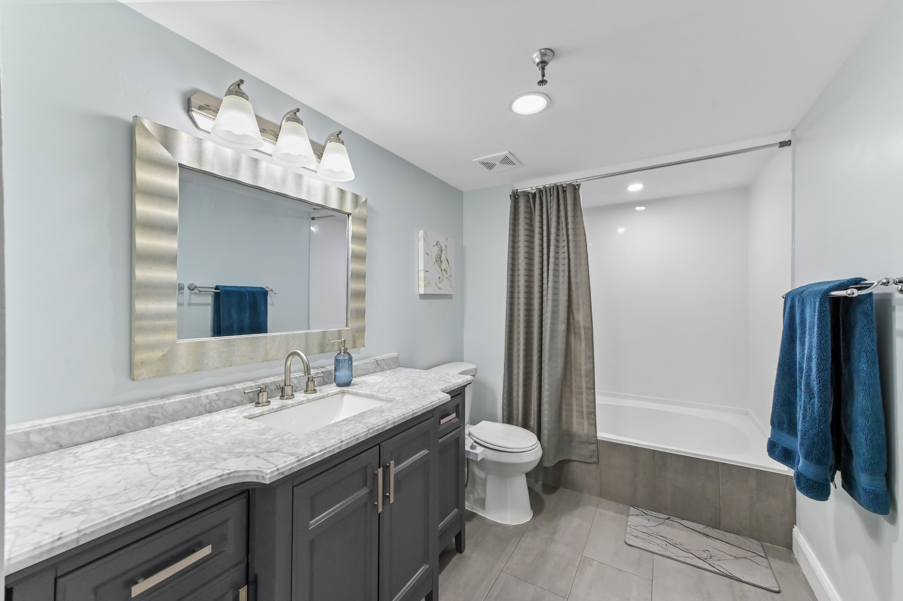198 Northwest 67th Street, Unit 207 Boca Raton, FL 33487 - Photo 22 of 42 a bathroom with a granite countertop sink a toilet a mirror and shower