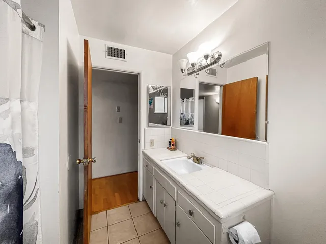 a bathroom with a double vanity sink mirror and shower