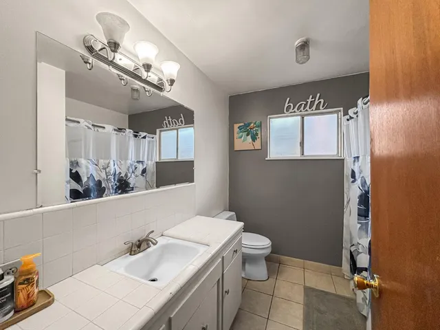 a bathroom with a sink a toilet and mirror