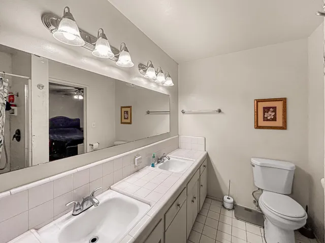 a bathroom with a sink a toilet and a mirror