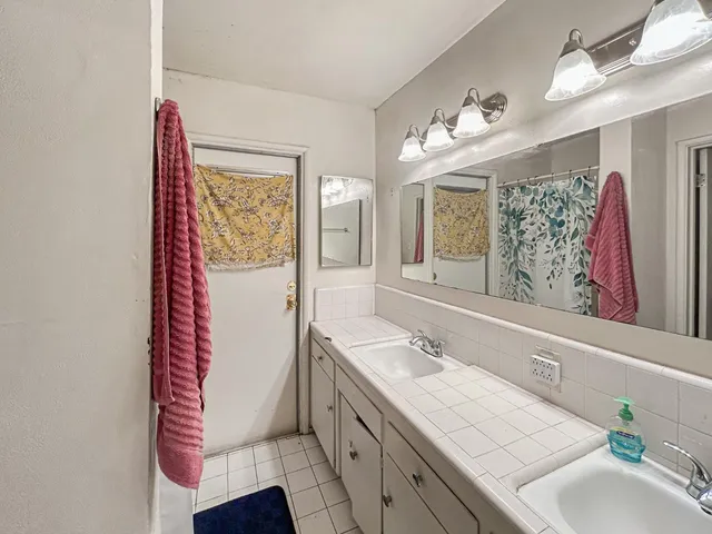 a spacious bathroom with a sink double vanity granite and a mirror