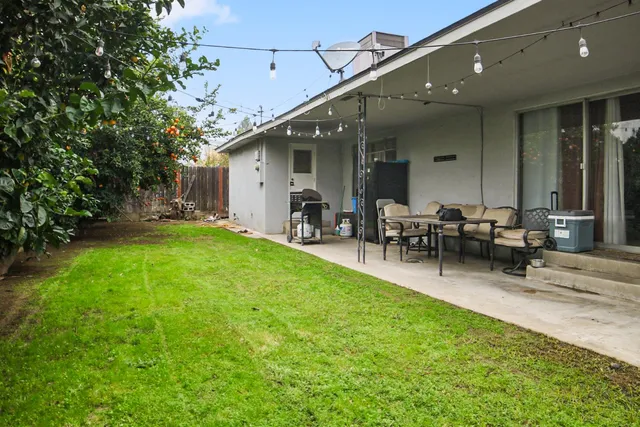 a view of a backyard with a patio and outdoor seating
