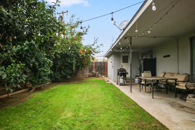 a view of a house with backyard and sitting area