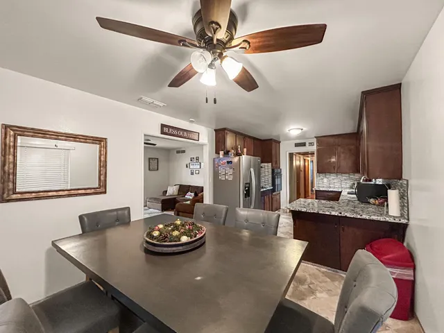 a view of a dining room with furniture and a chandelier fan
