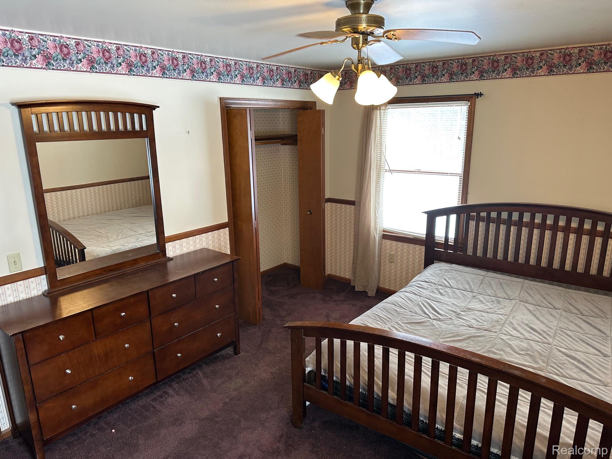 3803 Warner Road Cass City, MI 48726 - Photo 67 of 85 Bedroom featuring a wainscoted wall, wallpapered walls, dark colored carpet, a closet, and a ceiling fan
