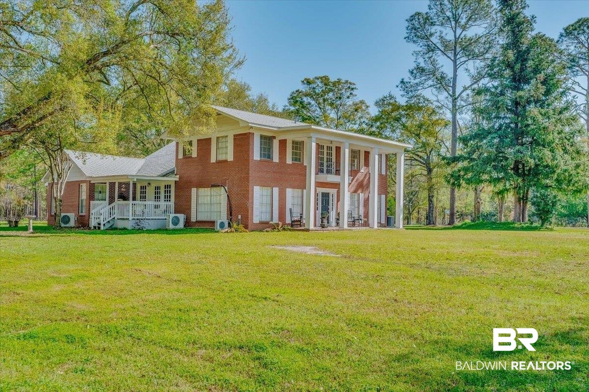 14160 Moffett Road Wilmer, AL 36587 - Photo 2 of 75 Greek revival house with covered porch, a front lawn, and ac unit