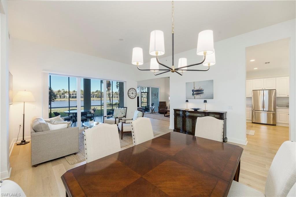 9288 Grassi Way, Unit 102 Naples, FL 34114 - Photo 11 of 37 a living room with fireplace furniture and a chandelier