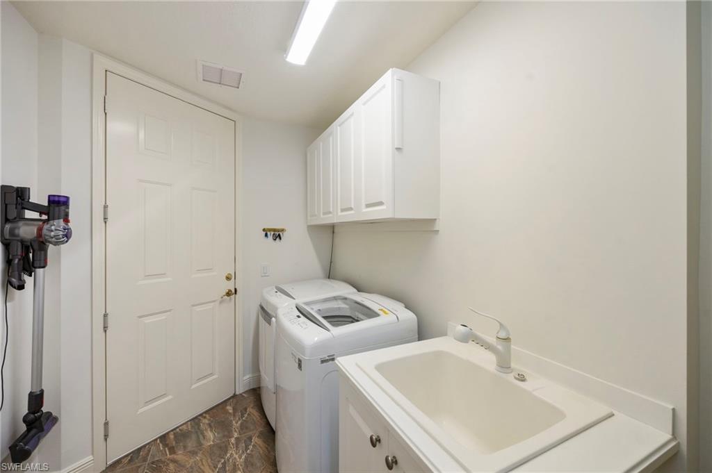 9288 Grassi Way, Unit 102 Naples, FL 34114 - Photo 22 of 37 Laundry room with separate washer and dryer and cabinet space and tiled floor